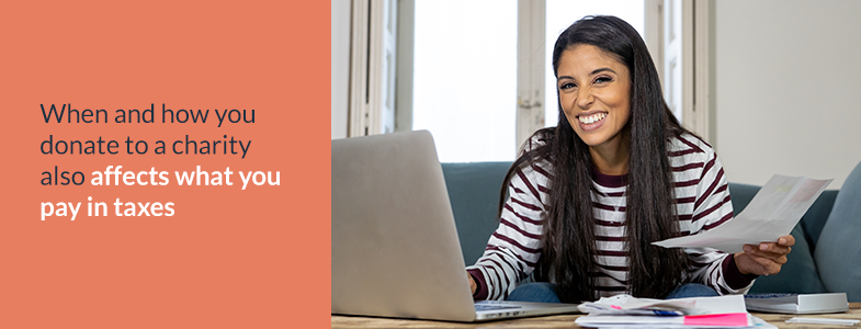 Woman smiling at a computer and holding financial documents