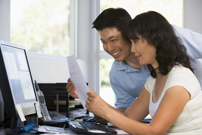 Two parents looking over finances for their children