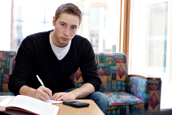 A teen completing their physics homework